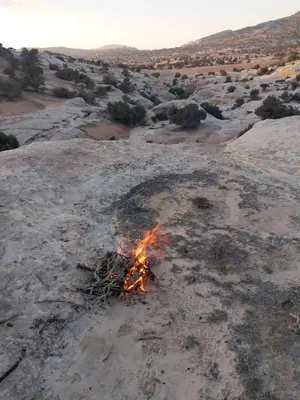 a fire burns in the middle of a field at Dana Hiking Camp - Dana Nature Reserve in Dana