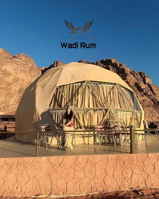 a woman sitting in a tent in the desert at Flora Camp Wadi Rum in Wadi Rum