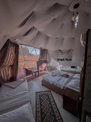 a bedroom with two beds and a wall run at Flora Camp Wadi Rum in Wadi Rum