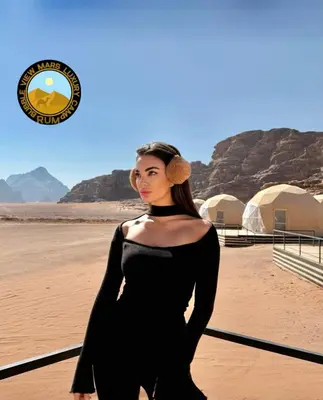 a woman in a black dress standing in the desert at RUM BUBBLES VIEW MARS lUXURY CAMP in Wadi Rum