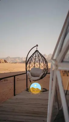a chair sitting on a boardwalk next to the beach at RUM BUBBLES VIEW MARS lUXURY CAMP in Wadi Rum