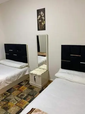 a room with two beds and a mirror at LINCON inn in Aqaba