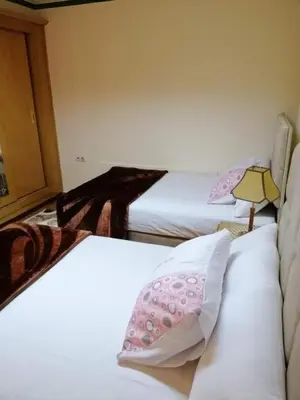a bedroom with two beds with pink and white pillows at LINCON inn in Aqaba