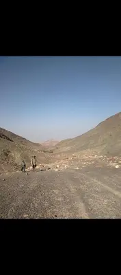two people walking down a dirt road in the desert at Dana to explore Bedouin life in Dana