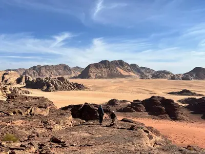 two people standing on a rock in the desert at Wanderlust Jordan Camp in Wadi Rum