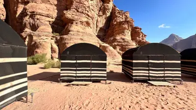 two black and white shelters in the desert at Wanderlust Jordan Camp in Wadi Rum