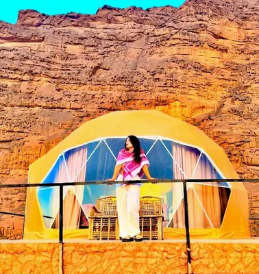 a woman standing in front of a dome tent at Rum plaza camp in Wadi Rum