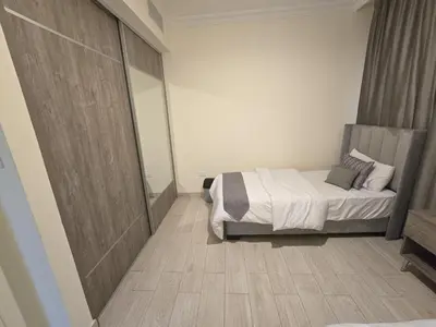 a bedroom with a bed and a wooden floor at Gardens Complex in Amman
