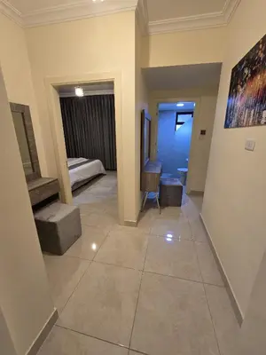 a hallway with a room with a bed and a table at Gardens Complex in Amman