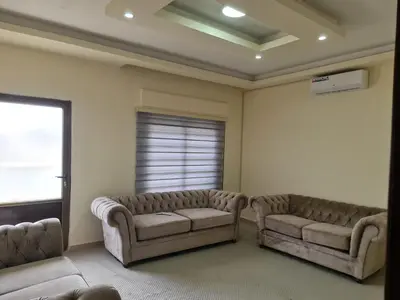 a living room with two couches and a window at Samer Apartment in Amman