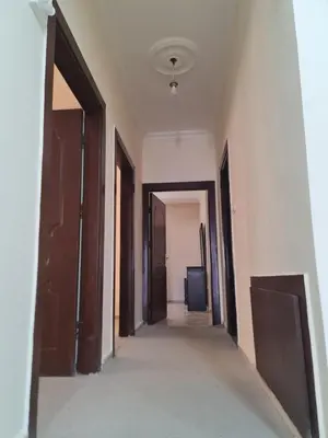 an empty hallway with doors and a room with a television at Samer Apartment in Amman