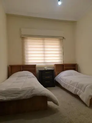 a bedroom with two twin beds and a window at Samer Apartment in Amman