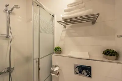 a bathroom with a shower and some towels at Shamsi Apartments 222 in Amman