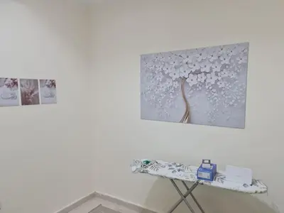 a table in a room with two pictures on the wall at Samer Apartment in Amman