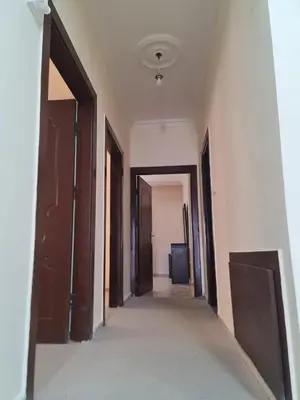 an empty hallway with doors and a television in a room at Samer Apartment in Amman