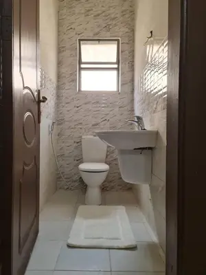 a bathroom with a toilet and a sink and a window at Samer Apartment in Amman