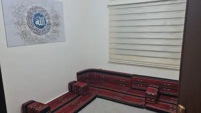 a red bench sitting next to a window at Samer Apartment in Amman