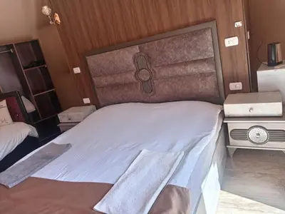 a bedroom with a white bed with a wooden headboard at calm Rum in Wadi Rum