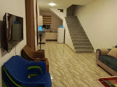 a living room with a staircase and a couch at شاليه الاميرات in Sowayma