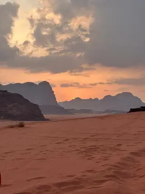 a sunset in the desert with mountains in the background at Luxury Desert Camp in Disah