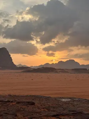 a sunset in the desert with mountains in the background at Luxury Desert Camp in Disah