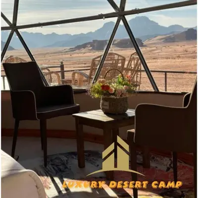 a room with two chairs and a table with a view of the desert at Luxury Desert Camp in Disah