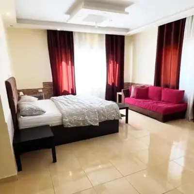 a bedroom with a bed and a red couch at Badr in Amman
