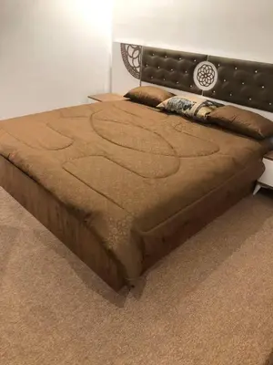 a large bed in a bedroom with a brown bedspread at almiddle house in Kafr Asad
