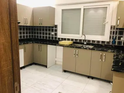 a kitchen with white cabinets and a sink at almiddle house in Kafr Asad