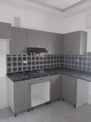 a kitchen with white cabinets and a stove top oven at almiddle house in Kafr Asad