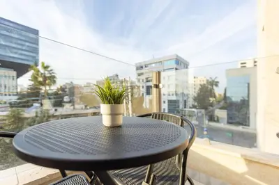 a black table with a potted plant on a balcony at Shamsi Apartments 329 in Amman