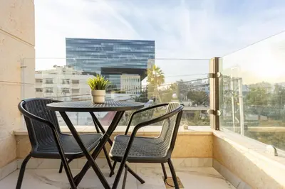 a table and two chairs on a balcony with a window at Shamsi Apartments 329 in Amman
