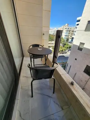 a table and chair sitting on a balcony at Shamsi Apartments 330 in Amman