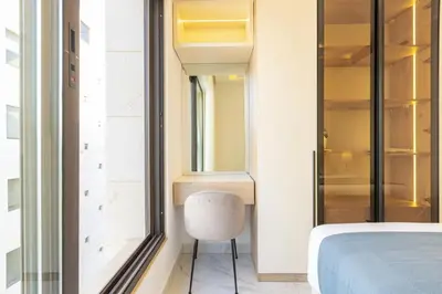 a bedroom with a bed and a chair next to a window at Shamsi Apartments 009 in Amman