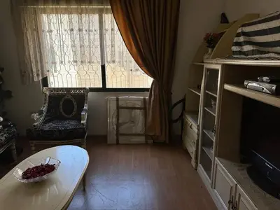 a living room with a table and a window at شقة مفروشة في حي نزال Furnished Apartment Hay Nazzal in Amman