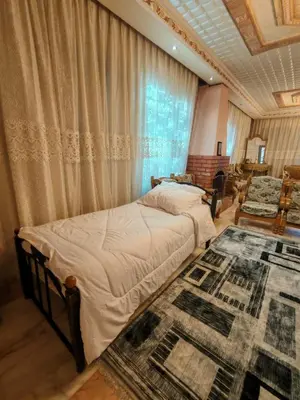 a bedroom with two beds and a large window at شقة مفروشة في البنيات - بالقرب من جامعة البتراء in Amman