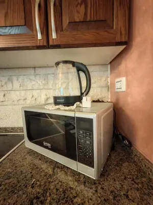 a microwave with a blender on top of it at شقة مفروشة في البنيات - بالقرب من جامعة البتراء in Amman