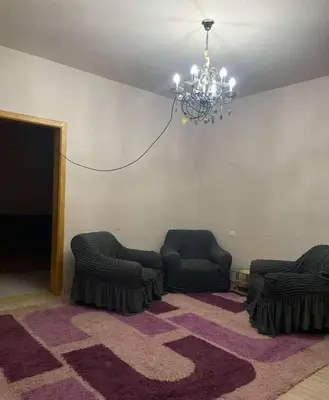 a living room with two chairs and a chandelier at kazbon House in Al Hāshimīyah