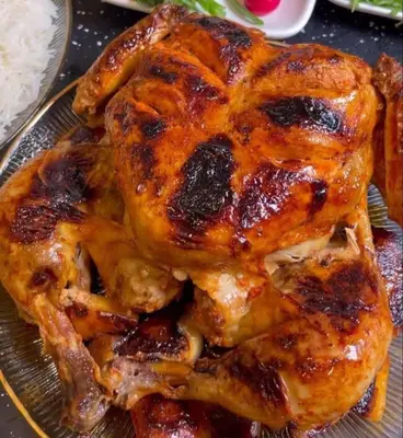 a close up of a chicken on a plate with rice at kazbon House in Al Hāshimīyah