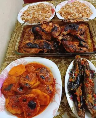 a table with plates of food and a tray of food at kazbon House in Al Hāshimīyah