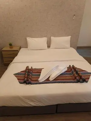 a bed with two blankets and towels on it at Gate Inn in Amman