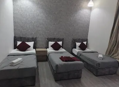 a room with two beds and a couch at Gate Inn in Amman