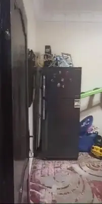 a kitchen with a black refrigerator in a room at birds House in Jerash