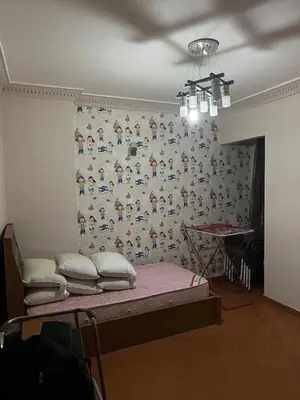 a room with a bed and a wall with a wallpaper at birds House in Jerash