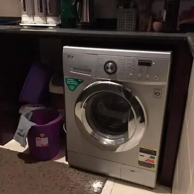 a washing machine sitting under a counter in a kitchen at birds House in Jerash