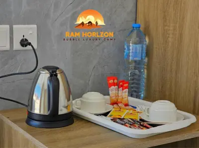 a tray with a tea kettle and a bottle of water at RAM HORlZON LUXURY CAMP in Wadi Rum