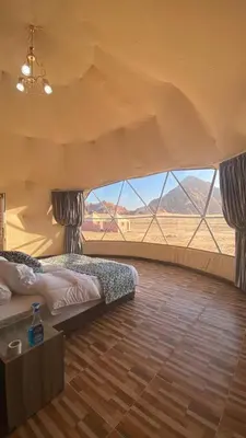 a bedroom with a bed and a view of the desert at Al-Faris Camp in Disah