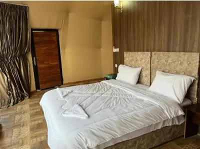 a bedroom with a large bed with white sheets and pillows at Al-Faris Camp in Disah