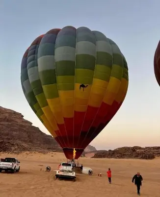 a large colorful hot air balloon in the desert at Al-Faris Camp in Disah