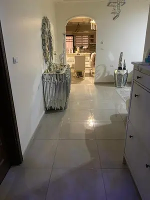 a living room with a tile floor and a kitchen at Amman Apartment 123 in Amman